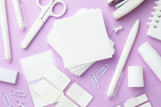 Different white stationery on violet background, flat lay