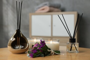 Spa composition with burning candles on wooden table indoors, closeup