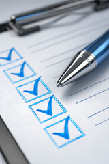 Blue pen rests on checklist with completed tasks indicated by checkmarks, on a clipboard, close-up shot.