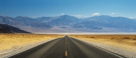 Naklejka premium The road stretching through the breathtaking desert landscape under a clear blue sky.