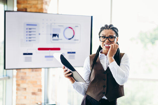 Professional businesswoman presenting analytics at an office conference while expressing nervous emotions during a presentation