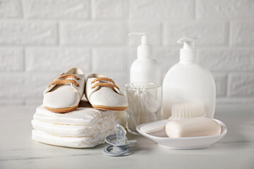 Many different baby accessories on table near brick wall