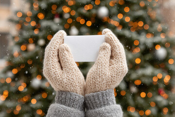 hands in warm mittens gently hold christmas greeting card adorned with heartfelt prayer