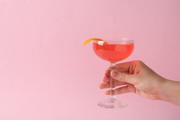 Woman with martini cocktail on pink background, closeup. Space for text