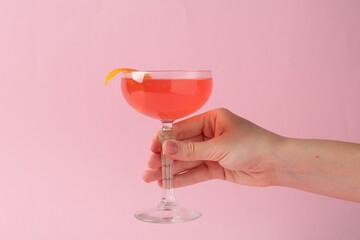 Woman with martini cocktail on pink background, closeup