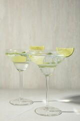 Martini cocktails with lime and mint on grey table