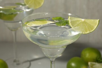 Martini cocktails with lime and mint on grey table, closeup