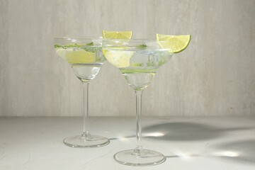 Martini cocktails with lime and mint on grey table