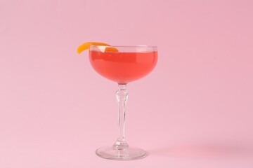 Martini cocktail with garnish on pink background