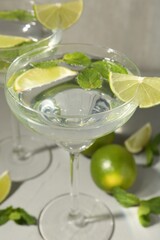 Martini cocktails with lime and mint on grey table, closeup