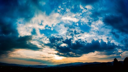 Dramatic panoramic landscape with expansive skies, dynamic clouds, silhouetted hills,