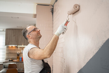 Man Painting a Wall With a Paint Roller