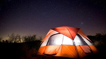 A bright orange tent stands out under a starry night sky, with warm light glowing from inside,
