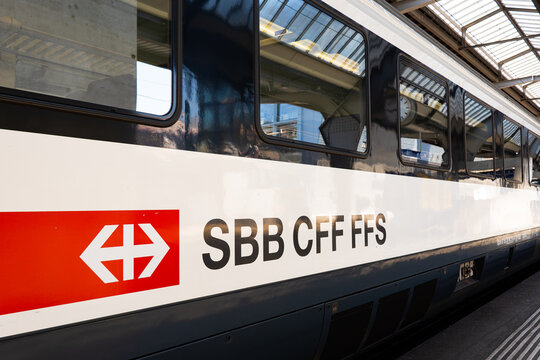Zurich, Switzerland, August 19, 2025. SBB CFF FFS decals or stickers on the side of a passenger train car stationed at main station ground floor platform. Wide angle view, daytime, no people