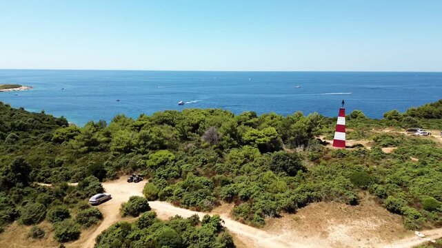 Aerial view of Cape Kamenjak lighthouse, forest and coastline in Istria, Croatia on a sunny day