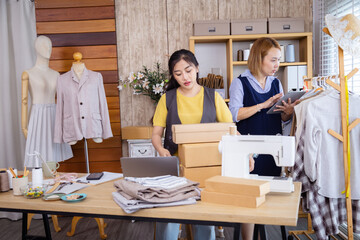 Asian dressmaker clothing partnership, fashion fabric small business packaging order delivery preparation, female partners managing clothing shop tasks together, balancing textile product shipment