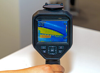 Male hand holding thermal camera tool in the air