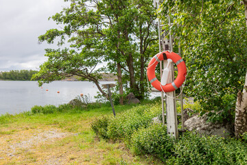 Close-up of lifebuoy at Finnish marina on the Baltic Sea. Safety equipment ready for emergency use, symbol of SOS, rescue, and maritime security in nautical environment