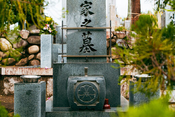 A traditional Japanese tomb within temple grounds, surrounded by stone and nature, reflecting spirituality, respect for ancestors, and the serene atmosphere of Buddhist heritage in Japan.