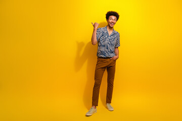 Fototapeta premium Charismatic young man in stylish summer wear gesturing optimistically against a vibrant yellow background