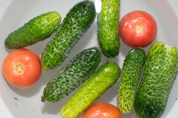Close up view of cucumbers and tomatoes soaked in water	