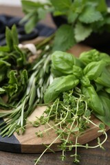 Different fresh green herbs on wooden table, closeup