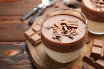 Delicious chocolate panna cotta in glasses on wooden table, closeup