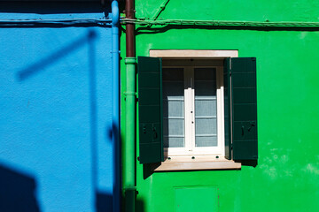blue window with green shutters, colorful houses in burano island