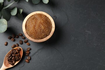 Natural body scrub, coffee beans and eucalyptus leaves on black table, flat lay. Space for text