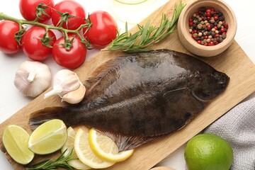 Fresh raw flounder fish and ingredients on white wooden table, flat lay. Seafood