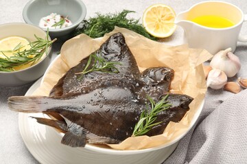 Fresh raw flounder fish and spices on light grey table, closeup. Seafood