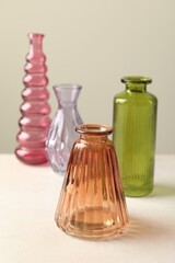 Different beautiful glass vases on white table against light grey background, closeup