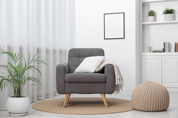 Comfortable grey armchair in living room. Interior design