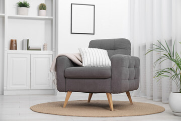 Comfortable grey armchair in living room. Interior design