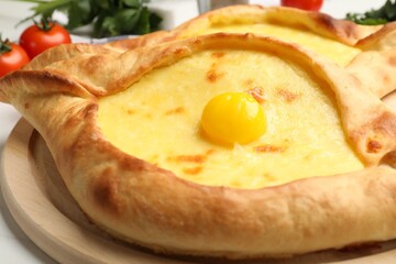 Tasty khachapuris with cheese and egg on table, closeup