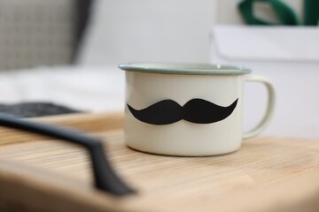 Happy Father's Day. Cup with mustache on bed at home, closeup