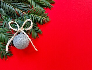 New Year's decoration on a Christmas tree branch against a red background