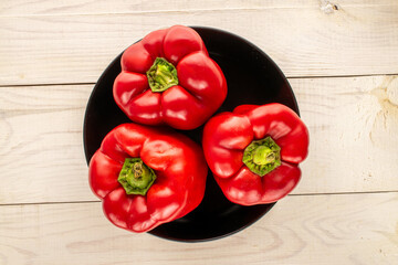Red bell peppers on a wooden table, close-up, top view.	