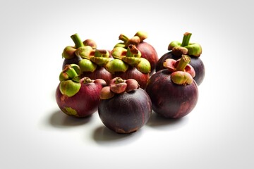 A cluster of fresh purple mangosteen fruits on a white background