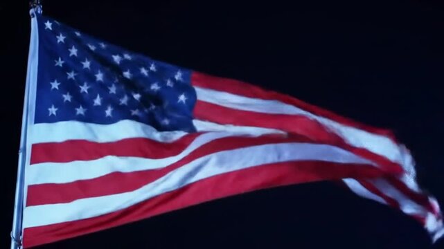 The American flag waves majestically against a dark night sky, symbolizing freedom and national pride.