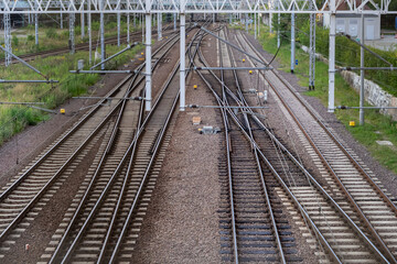 Intricate railway track system with multiple converging and diverging lines under overhead catenary, representing robust public transportation infrastructure and future paths