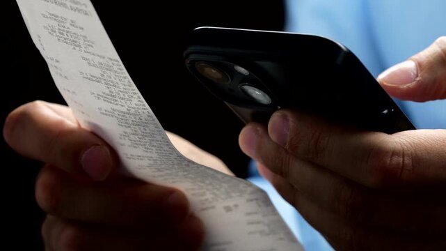 A person scans a QR code on a paper receipt with a mobile phone.
A paper check in the hands of a bank employee.
Online shopping with modern technology.
Payment of a receipt for services