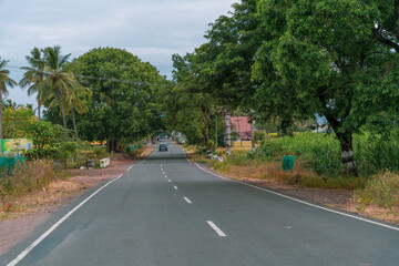 Fototapeta premium A road with a car driving down it