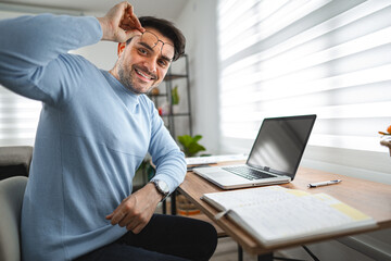 Portrait of smiling man at desk and laptop