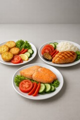 Assorted healthy meals with grilled chicken salmon potatoes rice and fresh vegetables served on white plates top view