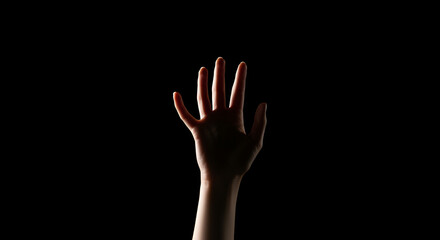Fototapeta premium Silhouette of a hand reaching up in the darkness, symbolizing hope and struggle
