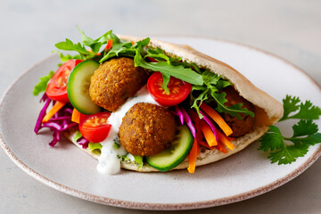 Healthy vegetarian falafel pita with fresh vegetables and sauce stock photo 