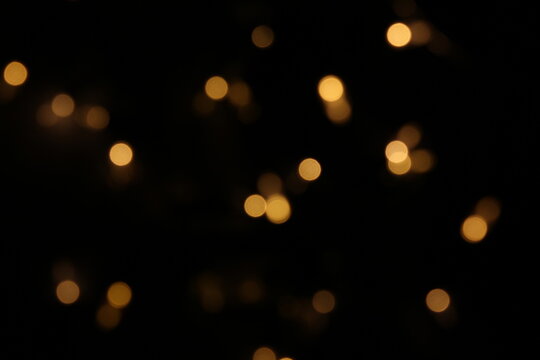 Christmas lights in bokeh. Outside in December. Red and fire orange bokeh on a black background, bokeh abstract background, modern technological abstract background. Orange Christmas background, Xmas 