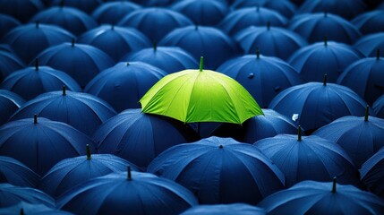 A single bright green umbrella stands out amongst a sea of dark blue umbrellas, symbolizing individuality and resilience against the rain