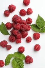 Tasty fresh ripe raspberries and leaves on white background, flat lay